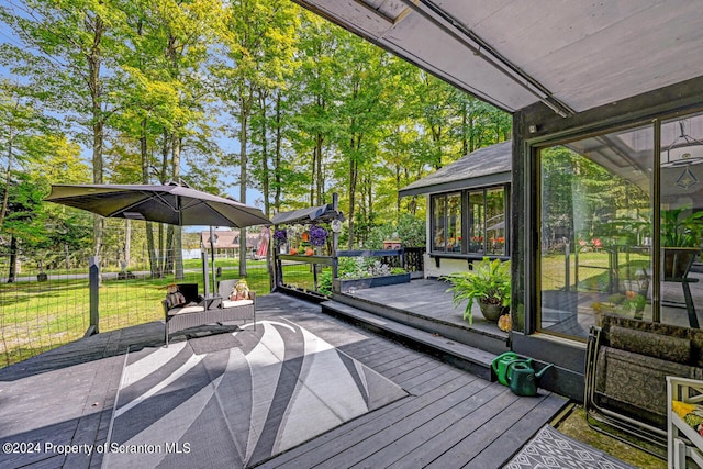 wooden deck featuring a yard and a sunroom