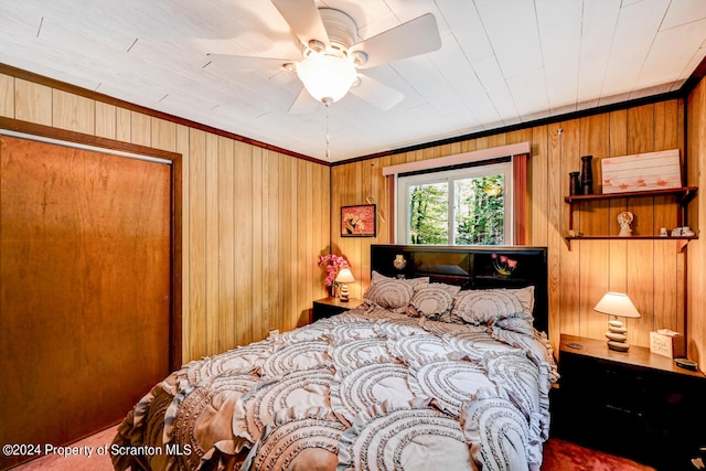 bedroom featuring ornamental molding, ceiling fan, wooden walls, and wood ceiling