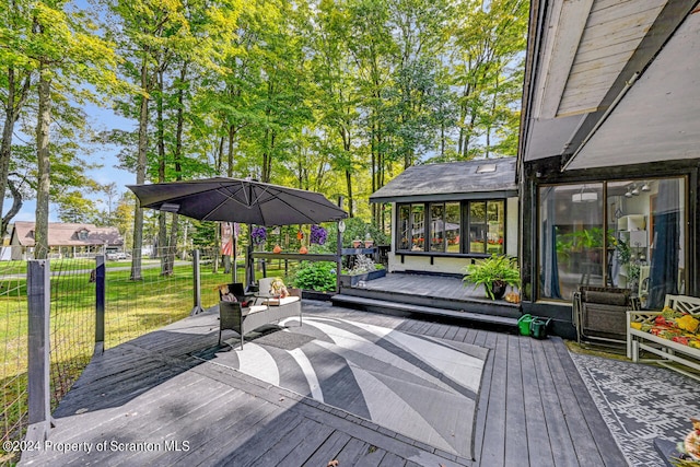 deck featuring a lawn and a sunroom