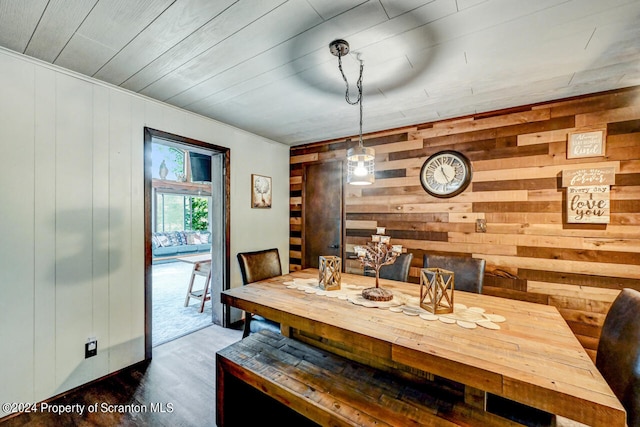 dining space with hardwood / wood-style floors, wood walls, and wood ceiling