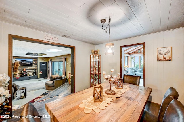 dining room featuring wooden walls and wood ceiling