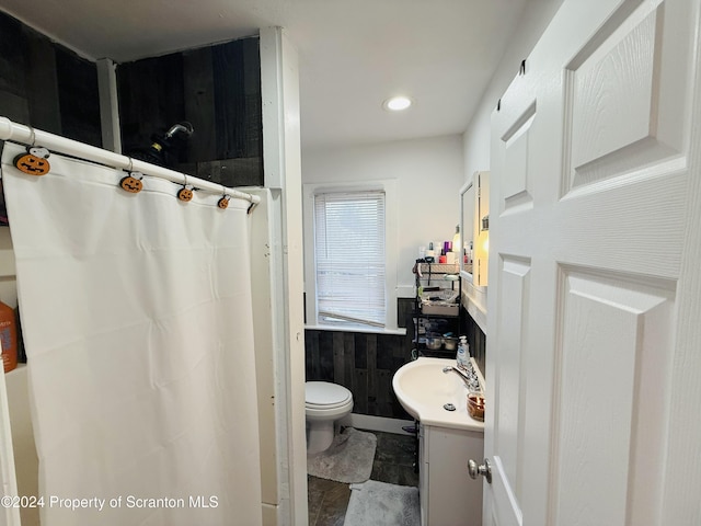 bathroom featuring tile walls, walk in shower, vanity, and toilet