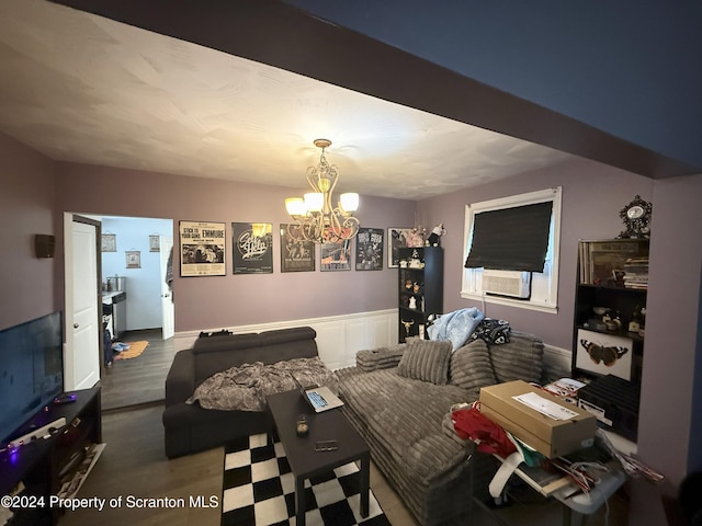 living room featuring cooling unit, an inviting chandelier, and hardwood / wood-style flooring