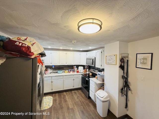 kitchen with stainless steel appliances, white cabinetry, a textured ceiling, and dark wood-type flooring