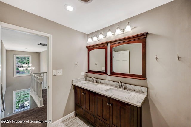 27 Emerson Dr, Moosic, PA 18507 - bathroom with a chandelier, double vanity, and baseboards