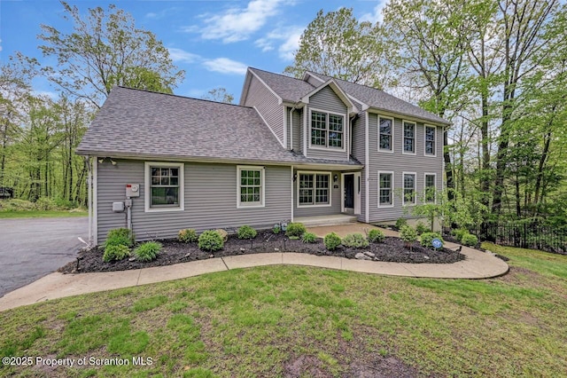 27 Emerson Dr, Moosic, PA 18507 - view of front of home with a front yard, a shingled roof, and covered porch