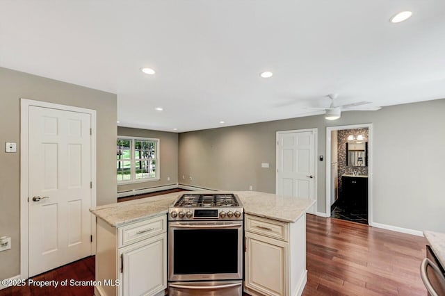 27 Emerson Dr, Moosic, PA 18507 - kitchen featuring stainless steel gas range, dark wood finished floors, a center island, a ceiling fan, and cream cabinetry