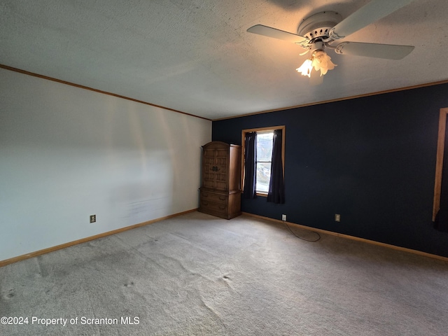 carpeted spare room featuring ceiling fan and ornamental molding