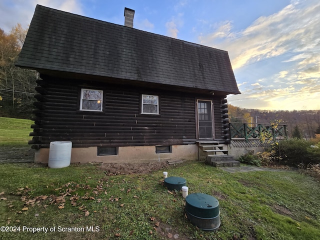 back house at dusk with a lawn