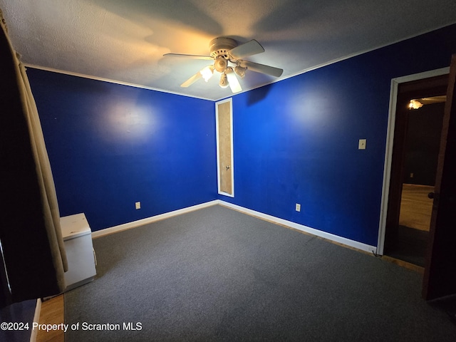 empty room featuring ceiling fan, carpet floors, and a textured ceiling