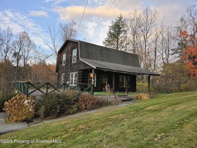 cabin with a lawn and covered porch