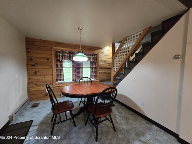 dining space featuring wood walls