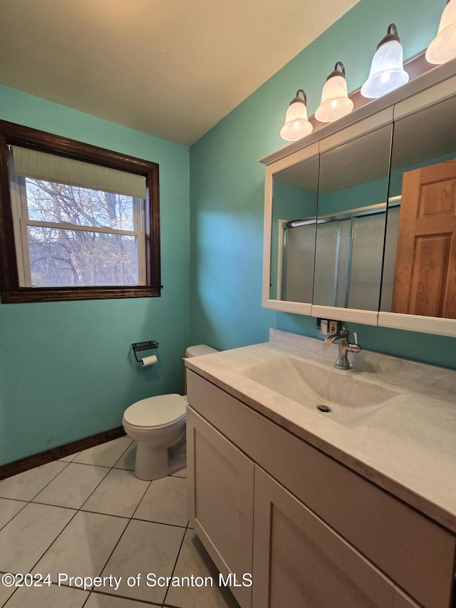 bathroom with tile patterned flooring, vanity, an enclosed shower, and toilet