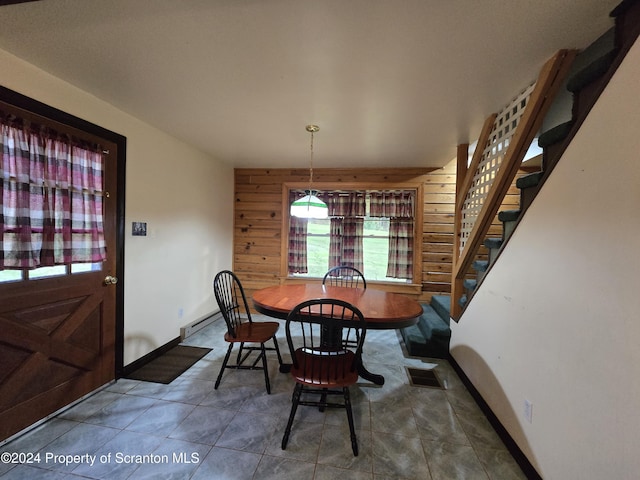 dining space featuring wood walls