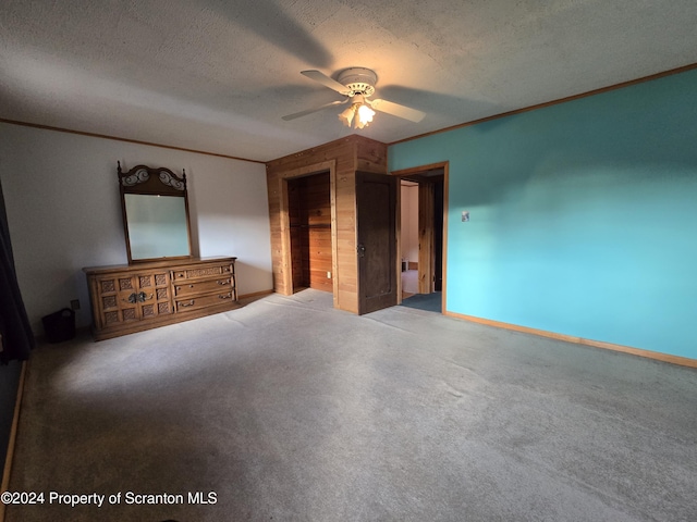 unfurnished bedroom featuring a textured ceiling, ceiling fan, crown molding, and carpet