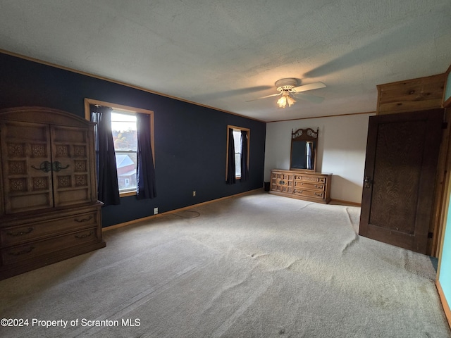 unfurnished bedroom with carpet, ceiling fan, crown molding, and a textured ceiling