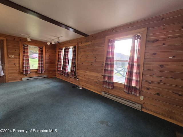 unfurnished room with beamed ceiling, track lighting, wooden walls, and a baseboard heating unit