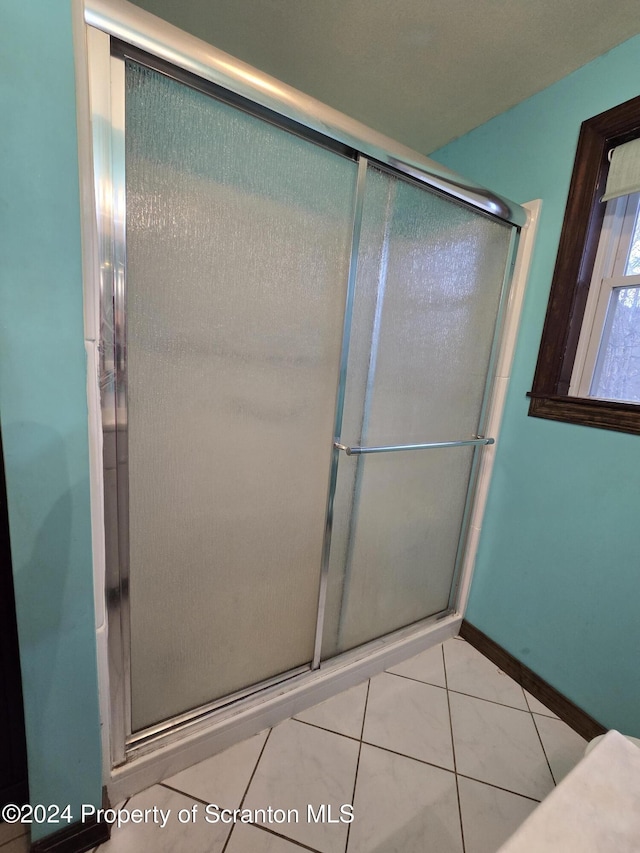 bathroom with tile patterned floors and a shower with shower door