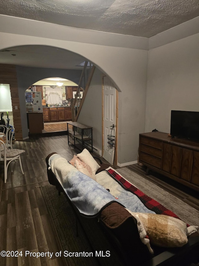 bedroom with a textured ceiling and dark hardwood / wood-style flooring