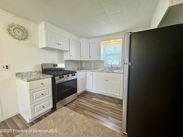 633 Thomas St, Eynon, PA 18403 - kitchen with stainless steel appliances, white cabinets, light stone counters, and dark wood-style flooring