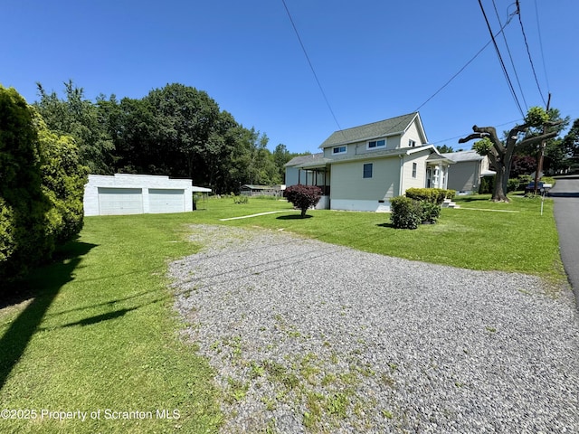 633 Thomas St, Eynon, PA 18403 - view of side of property with driveway, a detached garage, a lawn, and an outdoor structure