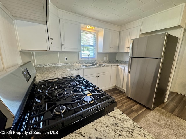 633 Thomas St, Eynon, PA 18403 - kitchen featuring freestanding refrigerator, gas range, dark wood-style flooring, white cabinetry, and light stone counters