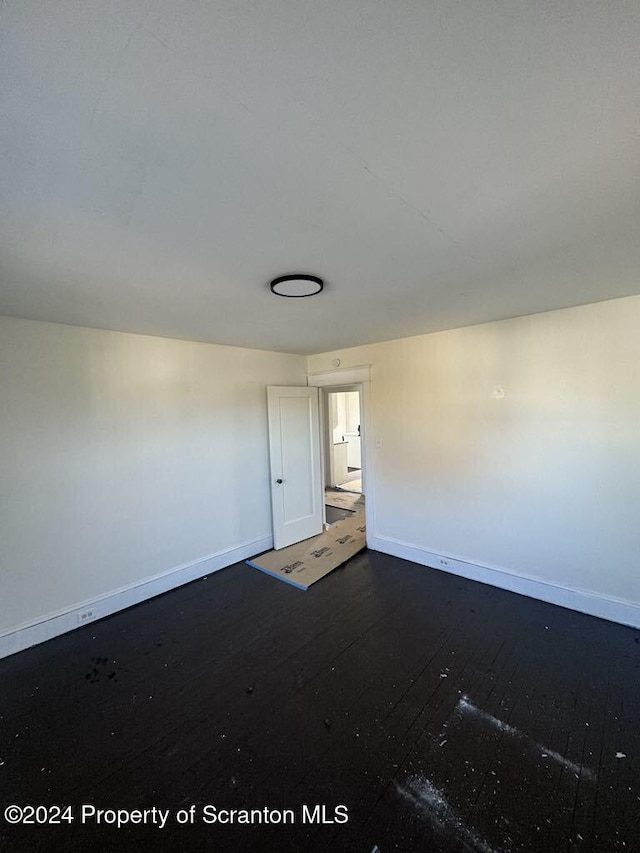 unfurnished room with dark hardwood / wood-style floors