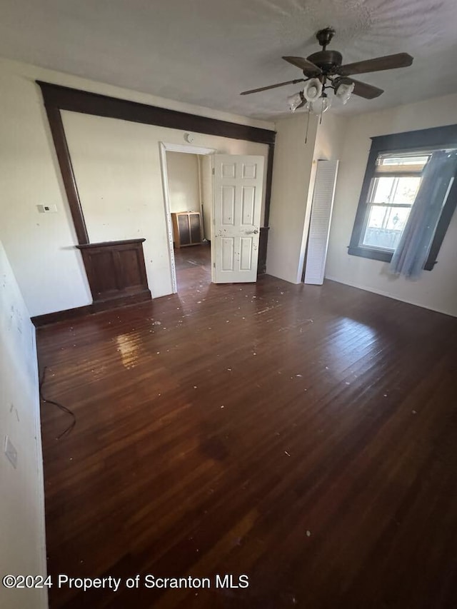 unfurnished room featuring ceiling fan and dark wood-type flooring