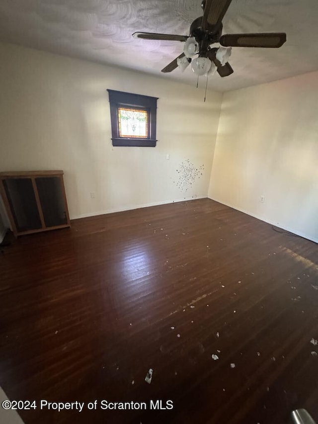 unfurnished room featuring dark hardwood / wood-style floors and ceiling fan