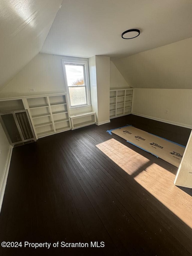 additional living space featuring lofted ceiling and dark hardwood / wood-style floors