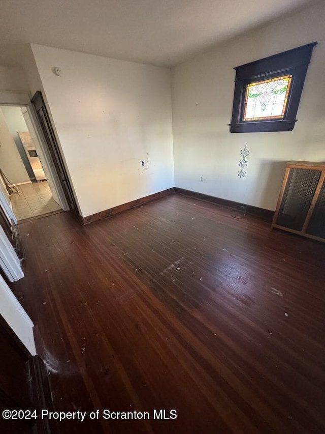 unfurnished room with dark wood-type flooring