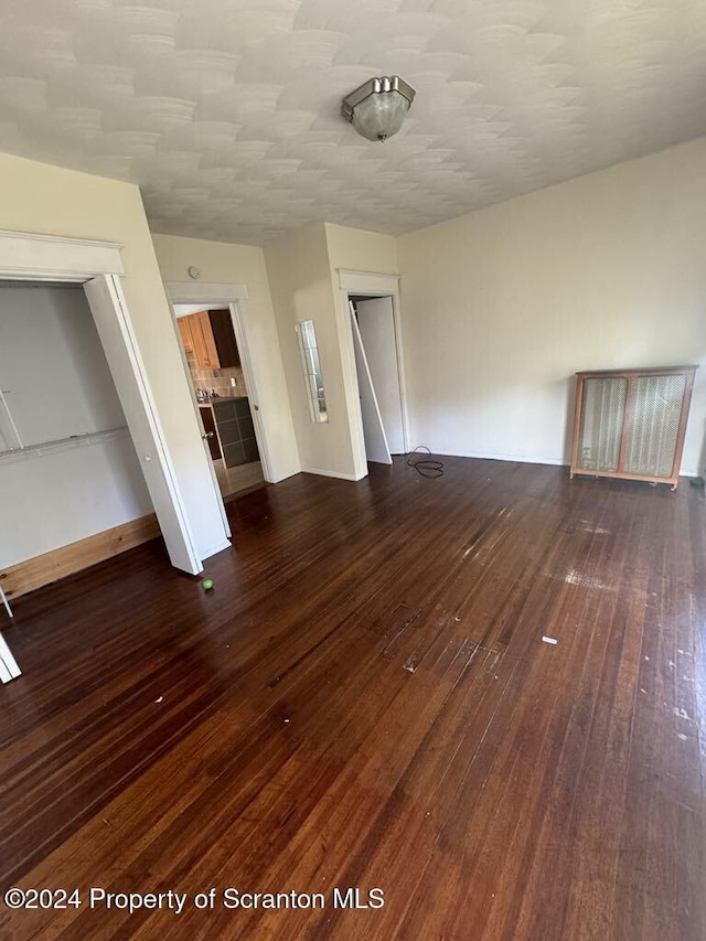 unfurnished living room featuring dark wood-type flooring