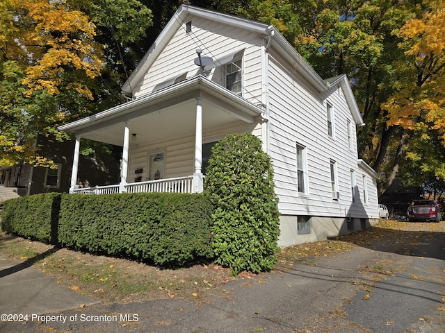 view of side of home featuring covered porch