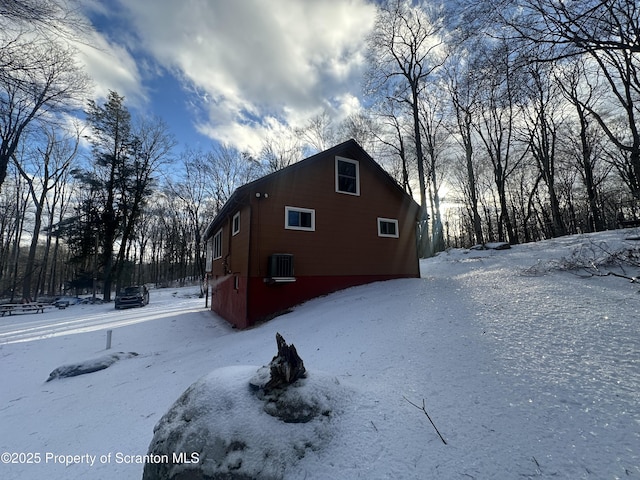 view of snow covered exterior with central AC unit