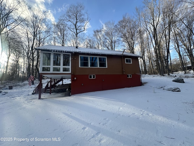 105 Hughes Dr, Greene Twp, PA 18426 - snow covered rear of property featuring a sunroom and a metal roof