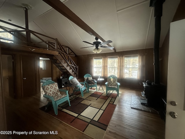 105 Hughes Dr, Greene Twp, PA 18426 - living area featuring a wood stove, wood finished floors, ceiling fan, stairs, and wood walls