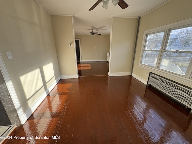 empty room with dark hardwood / wood-style floors, an AC wall unit, ceiling fan, and crown molding