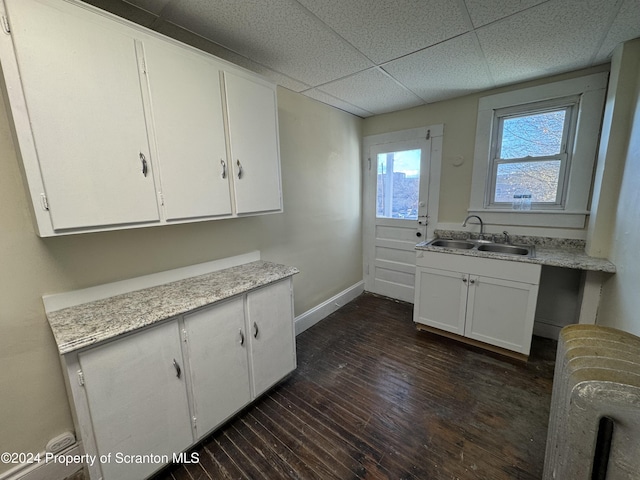 kitchen featuring a drop ceiling, radiator, sink, dark hardwood / wood-style flooring, and white cabinetry