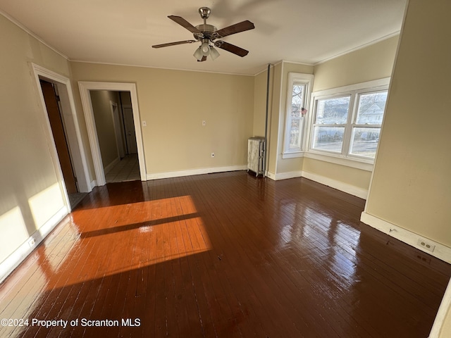 spare room with radiator, dark hardwood / wood-style floors, ceiling fan, and crown molding