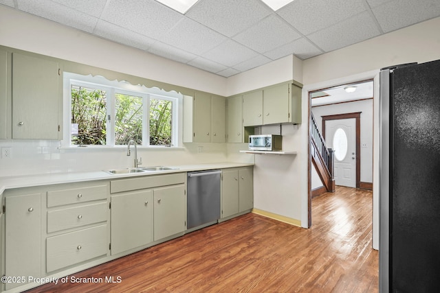 50 Harlem Ave, Carbondale, PA 18407 - kitchen with stainless steel appliances, a sink, backsplash, wood finished floors, and a paneled ceiling