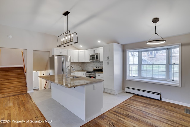 kitchen with stainless steel appliances, sink, a baseboard radiator, white cabinetry, and hanging light fixtures