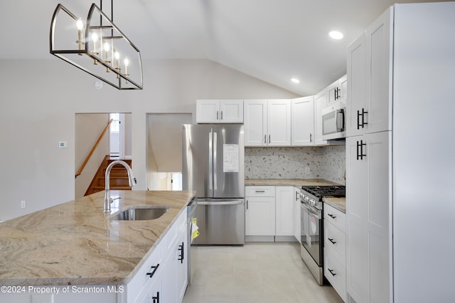 kitchen featuring white cabinets, lofted ceiling, sink, and appliances with stainless steel finishes