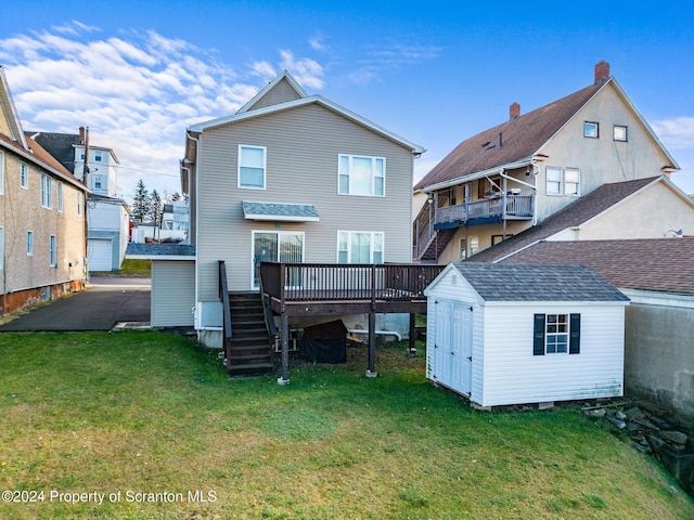 back of property with a yard, a storage shed, and a wooden deck