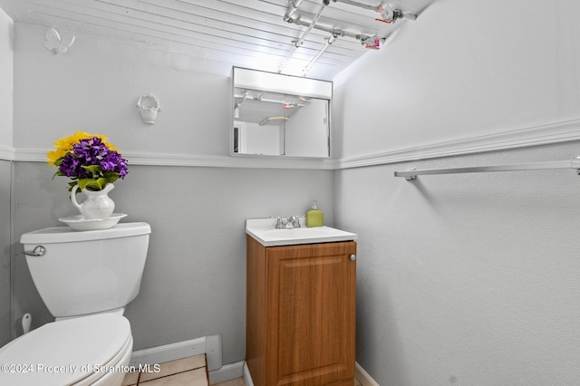 bathroom featuring tile patterned flooring, vanity, and toilet