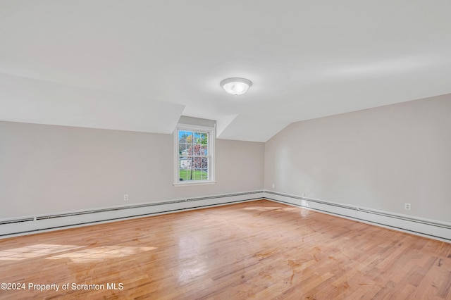 additional living space with light wood-type flooring and vaulted ceiling