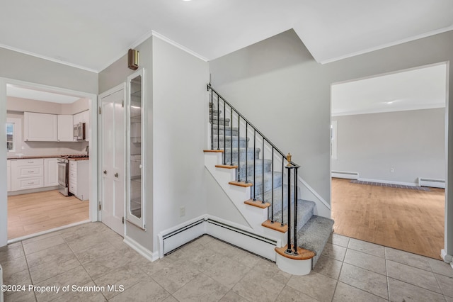 stairs featuring baseboard heating, crown molding, and tile patterned flooring