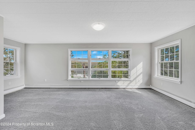 spare room featuring carpet and a baseboard heating unit