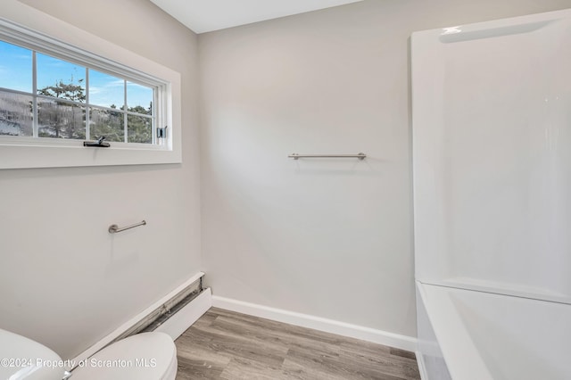 bathroom with hardwood / wood-style floors and toilet