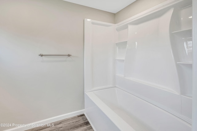 bathroom with bathtub / shower combination and hardwood / wood-style floors