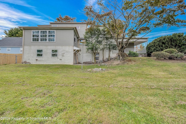 rear view of house featuring a yard